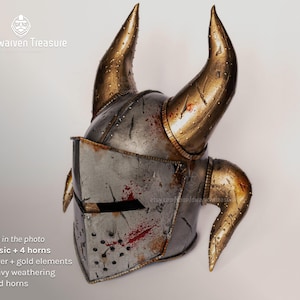 Medieval warrior helmet with four golden horns and face visor. Heavy battle damage weathering.