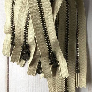 Beige YKK Zippers. 10-inch. Color 010. [3, 5] Pieces. Antique Brass Donut Pulls. Metal Zipper, Closed Bottom. Bag supplies. Light Brown. Tan