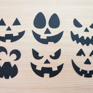 May include: Set of six black felt Halloween pumpkin face cutouts. The cutouts feature different facial expressions, including a classic jack-o'-lantern, a scary face, and a goofy face.