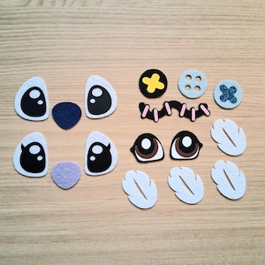 May include: A collection of felt craft pieces, including eye shapes, noses, buttons, and feather-like shapes. The pieces are in various colors, including black, white, blue, yellow, and brown. These craft supplies are ideal for DIY projects.