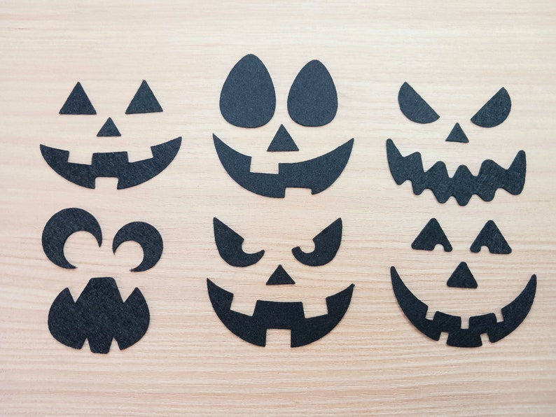 May include: Set of six black felt Halloween pumpkin face cutouts. The cutouts feature different facial expressions, including a classic jack-o'-lantern, a scary face, and a goofy face.