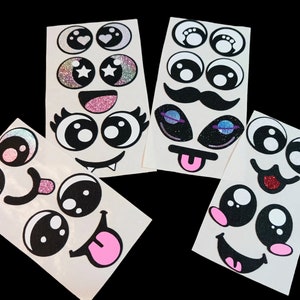 May include: Five sheets of white sticker paper with various black and white cartoon eyes, mouths, and noses. Some of the stickers have glitter accents.
