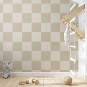 Könnte beinhalten: Ein neutrales Kinderzimmer mit einer karierten Wand in Beige und Off-White. Eine Holz-Kletterstruktur mit einem hängenden Stofftier, ein graues Hasenplüschtier, Holzhanteln und ein Ball liegen auf dem Holzboden.
