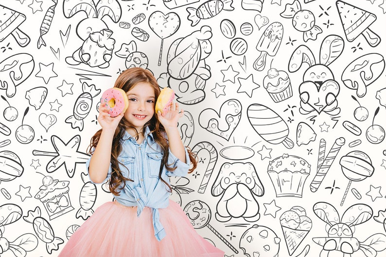 There is happy girl and coloring wallpaper for kids rooms with black outlines in doodle style in the background.
The product is a DIY wall art for coloring. Wallpaper design  showcases cartoon expressive faces characters, all radiating positive vibes