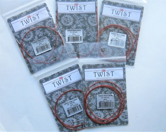 May include: Five packages of red Twist interchangeable knitting needles cables. The cables are in different sizes: 14 inches, 22 inches, 27 inches, 30 inches, and 37 inches. Each package has a white label with the Twist logo and the text "Twist Red Cable" and the size of the cable.