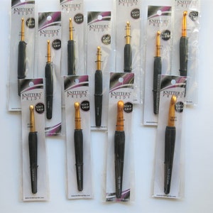 May include: A set of 10 black and gold crochet hooks with soft grip handles. The hooks are packaged individually and labeled "Knitter's Pride Soft Grip".