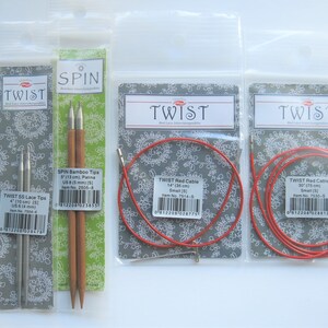 May include: Three packages of knitting needles and cables. The first package contains two silver Twist SS Lace Tips, 4 inches (10 cm) long. The second package contains two brown Spin Bamboo Tips, 5 inches (13 cm) long. The third and fourth packages contain red Twist Red Cable, 14 inches (35 cm) and 30 inches (75 cm) long.