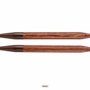 May include: A pair of brown wooden knitting needles with metal tips. The needles are approximately 10 inches long.