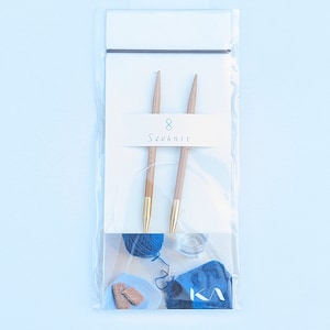 May include: A pair of wooden knitting needles in a clear plastic bag with a white label that says "Seeknit 8".