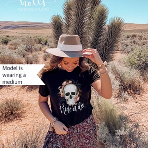 May include: Black t-shirt with a floral skull graphic and the text "Ride or Die". The model is wearing a medium size.