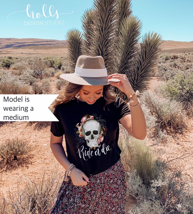 May include: Black t-shirt with a floral skull graphic and the text "Ride or Die". The model is wearing a medium size.
