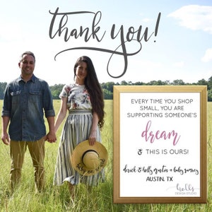 May include: A couple stands in a field holding hands. A sign reads "Every time you shop small, you are supporting someone's dream & this is ours!"  The sign also includes the text "derick & holly martin + baby ramsey AUSTIN, TX holls DESIGN STUDIO".