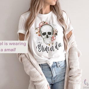 May include: White t-shirt with a floral skull graphic and the text "Ride or Die".