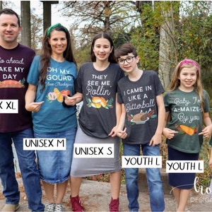 May include: A family of six wearing Thanksgiving themed t-shirts. The shirts feature various Thanksgiving-related puns and designs, including a turkey, a pumpkin, and a cornucopia. The shirts are available in a variety of sizes, including unisex XL, unisex M, unisex S, youth L, and youth S.