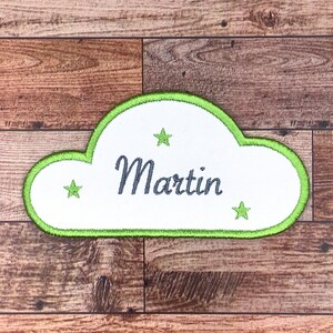 Peut inclure: Un patch en forme de nuage blanc avec une bordure verte et trois étoiles vertes. Le nom "Martin" est brodé en gris sur le patch.