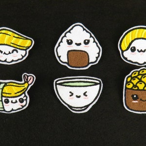 May include: Six embroidered iron-on patches featuring cute cartoon faces of Japanese food. The patches include a bowl of ramen, a sushi roll, a piece of nigiri, a rice ball, a bowl of edamame, and a piece of maki.