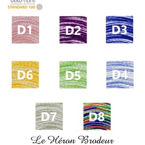 May include: Eight spools of embroidery floss in different colours, including pink, purple, blue, yellow, green, light blue, grey, and rainbow. The spools are labelled with the letters D1 through D8. The text "OEKO-TEX&reg; CONFIDENCE IN TEXTILES STANDARD 100" and "Le H&eacute;ron Brodeur" are also visible.