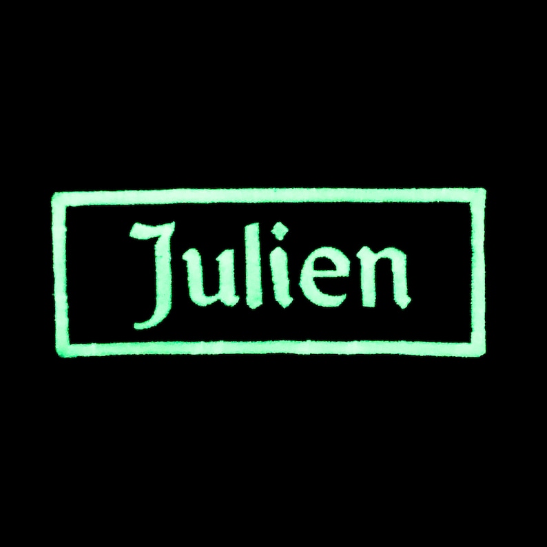 K&ouml;nnte beinhalten: Ein gr&uuml;nes Rechteck mit wei&szlig;em Rand und dem Wort "Julien" in einer stilisierten Schrift.