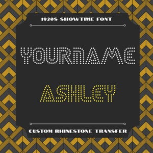May include: A black background with the text "YOURNAME" in white rhinestone dots and "ASHLEY" in yellow rhinestone dots. The text "1920S SHOWTIME FONT" and "CUSTOM RHINESTONE TRANSFER" are also present.