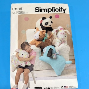 May include: A Simplicity sewing pattern featuring stuffed animal designs, including a panda, bunny, dog, and cat. The pattern is labeled "easy-to-sew" and includes the text "Designed and printed in USA."