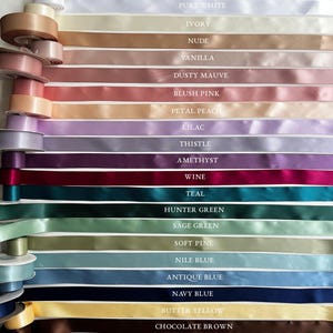 May include: A variety of satin ribbons in a spectrum of colors, including black, white, and shades of pink, purple, and green. Each ribbon is labeled with its color name, such as "Teal" and "Navy Blue". The ribbons are neatly arranged, showcasing their smooth texture.