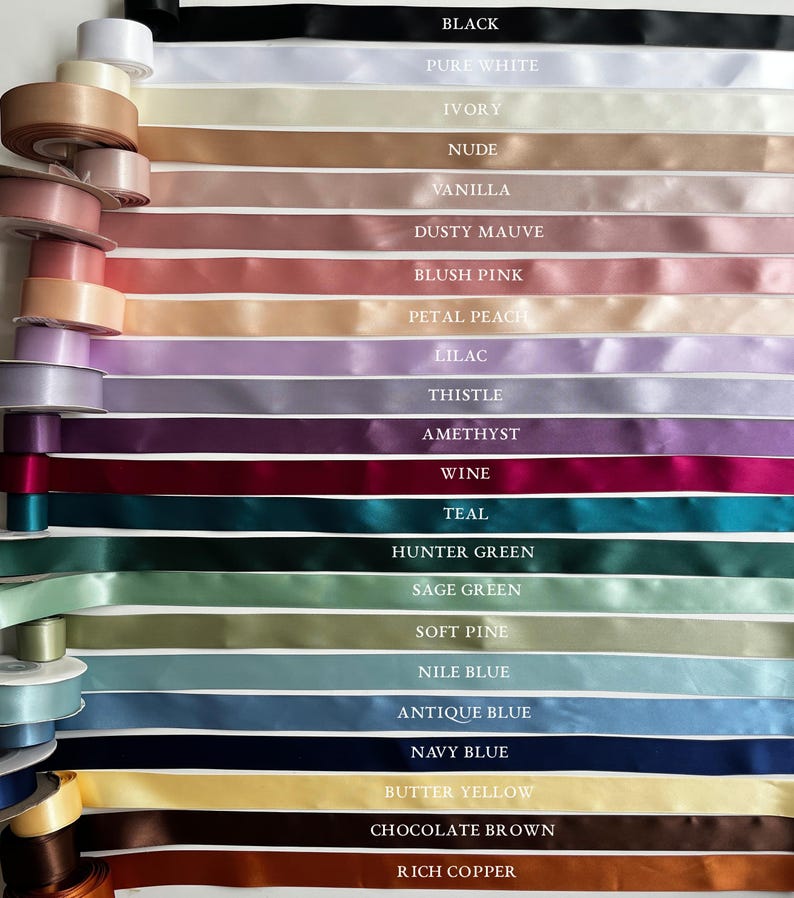 May include: A variety of satin ribbons in a spectrum of colors, including black, white, and shades of pink, purple, and green. Each ribbon is labeled with its color name, such as "Teal" and "Navy Blue". The ribbons are neatly arranged, showcasing their smooth texture.