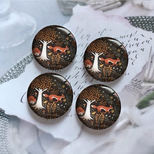 May include: Four round, glossy buttons with a woodland scene. Each button features a running fox, a white tree, and autumn foliage in shades of brown, orange, and white against a dark background. The buttons are approximately 1 inch in diameter.
