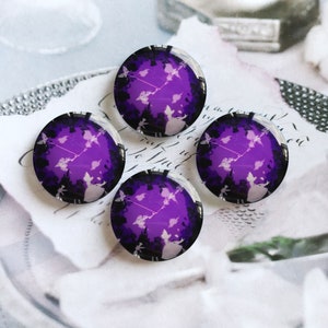 Könnte beinhalten: Vier runde Glascabochons mit einem violetten Hintergrund und einer weißen Silhouette einer Fee mit einem Zauberstab und einem Schmetterling. Die Fee ist von anderen Schmetterlingen umgeben.