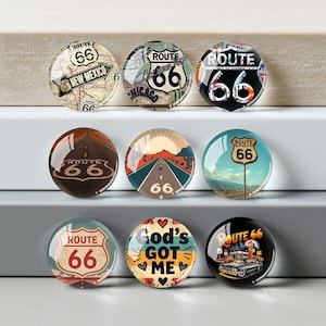 May include: Nine Route 66 themed glass cabochons with various designs. The designs include maps, road scenes, and the Route 66 logo. Some cabochons feature the text "New Mexico", "Chicago", and "God's Got Me".
