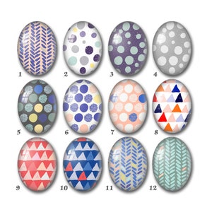 May include: Twelve oval-shaped glass cabochons with different geometric patterns. The patterns include polka dots, triangles, and zigzags in various colours, including blue, red, pink, yellow, and grey.
