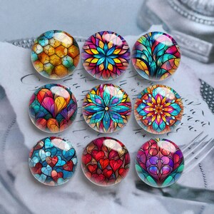 May include: Nine circular glass cabochons featuring vibrant, multi-coloured stained glass patterns. The designs include geometric honeycomb shapes, intricate floral mandalas, and repeating heart motifs in shades of blue, red, yellow, and purple.