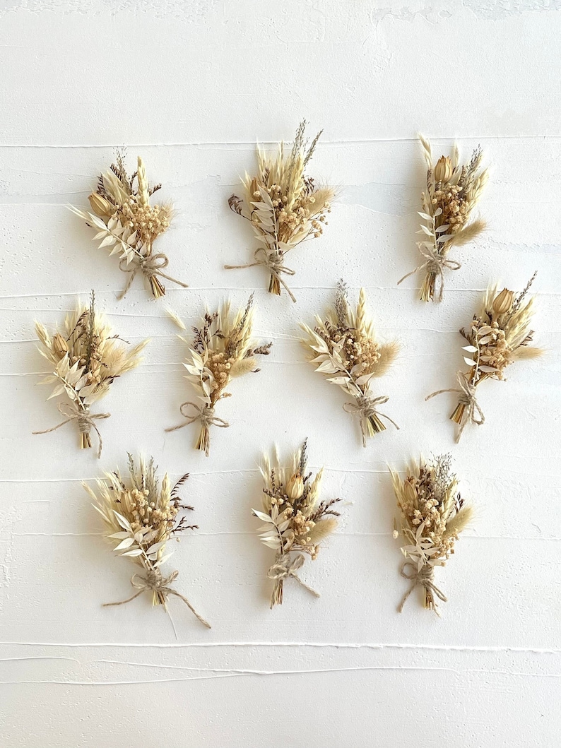 May include: Ten small bouquets of dried flowers in shades of beige and brown, tied with twine, arranged in rows on a white background.