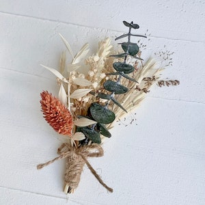 These mini bouquets feature a boho and unique mix of real dried flowers, making them perfect boutonnieres for rustic boho weddings