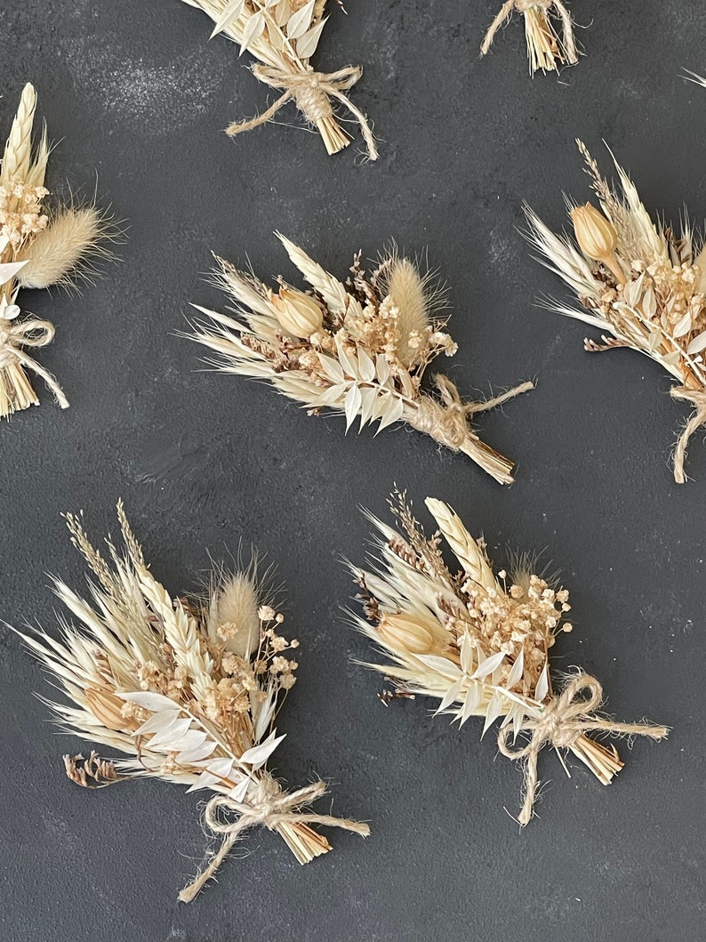 May include: A set of six dried flower bouquets tied with twine. Each bouquet features a variety of dried grasses, flowers, and seed pods in shades of beige and cream.