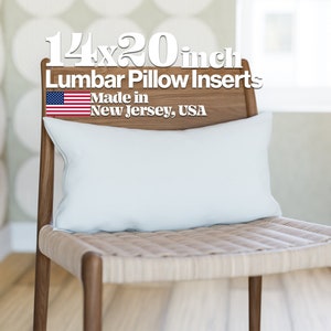May include: A white lumbar pillow insert on a wooden chair. The pillow is 14x20 inches and made in New Jersey, USA. The text "14x20 inch Lumbar Pillow Inserts Made in New Jersey, USA" is displayed above the pillow.