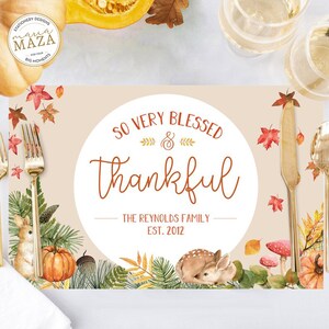 Könnte beinhalten: Ein beiger Platzteller mit einem weißen Kreis in der Mitte. Der Kreis enthält den Text "So Very Blessed & Thankful" in brauner Schrift. Unter dem Text steht "The Reynolds Family Est. 2012". Der Platzteller ist mit Herbstblättern, einem Kürbis, einem Reh und Pilzen verziert.