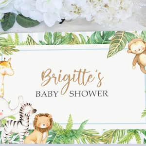 May include: A jungle-themed baby shower place card with a blue and white border. The card features a giraffe, elephant, zebra, lion, and monkey. The text on the card reads "Brigitte's Baby Shower".