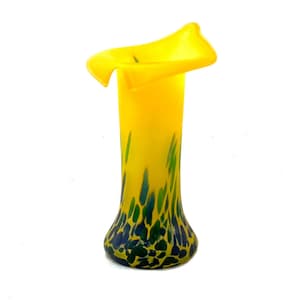 Könnte beinhalten: Eine gelbe Glasvase mit einer ausgestellten Öffnung und einem grün-blauen gesprenkelten Design.