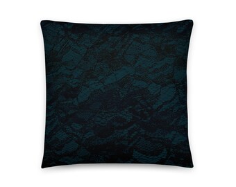 Puede incluir: Una almohada cuadrada de color azul oscuro con un patrón de encaje negro.
