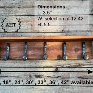 May include: A wooden shelf with five metal hooks, measuring 3.5 inches in length, 5.5 inches in height, and available in widths from 12 to 42 inches. The shelf is made of reclaimed wood and has a rustic finish. The hooks are made of black metal and have a hammered finish. The shelf is perfect for hanging coats, hats, keys, or other items.