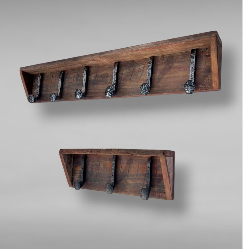 May include: Two wooden wall-mounted coat racks with metal hooks. The top rack has six hooks and the bottom rack has four hooks.