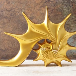 以下が含まれることがあります： 黄金色の抽象彫刻。 螺旋と星のような尖った要素があります。 彫刻は滑らかで反射する表面を持ち、テクスチャ加工された茶色と白の背景に配置されています。 デザインは貝殻を連想させます。