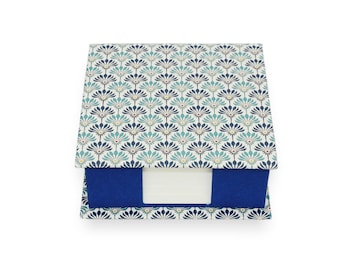 May include: A blue and white patterned notepad with a blue sticky note attached. The notepad has a floral design.