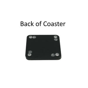 Puede incluir: Un posavasos cuadrado negro con cuatro topes circulares transparentes en las esquinas. El texto "Back of Coaster" est&aacute; impreso en negro encima del posavasos. El posavasos est&aacute; sobre un fondo blanco.