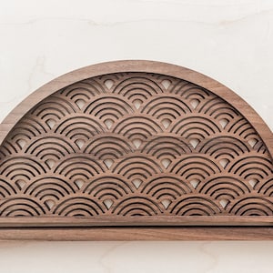 May include: A half-circle wooden shelf with a decorative pattern of overlapping arches cut out. The shelf is made of dark wood and has a smooth, polished finish.