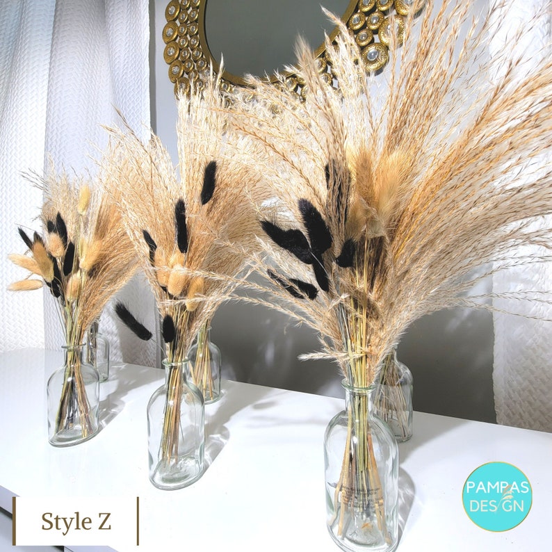 May include: Three clear glass vases filled with dried pampas grass, black and beige dried flowers, and the text "Style Z" in the bottom left corner.