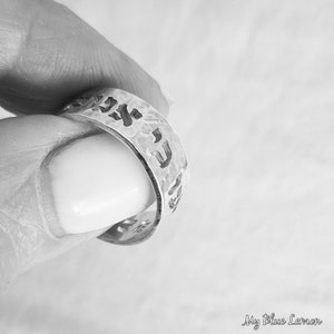 May include: A silver ring with Hebrew lettering engraved on the band.