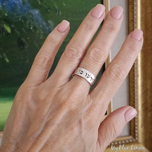 May include: A silver ring with Hebrew lettering on the band.
