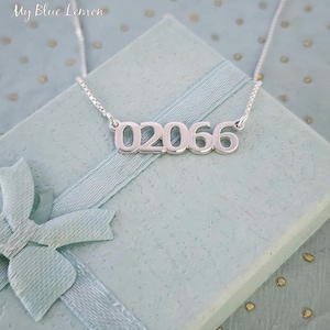 May include: Silver necklace with a pendant featuring the numbers 02066. The necklace is displayed on a light blue gift box with a white ribbon.
