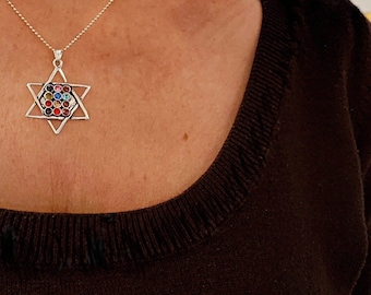 May include: A silver chain necklace with a silver Star of David pendant featuring colorful gemstones.